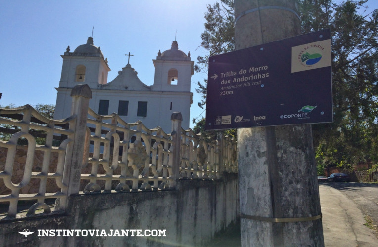 Igreja de São Sebastião de Itaipu e a placa informando para seguir pela direita, entrando na rua da Amizade.