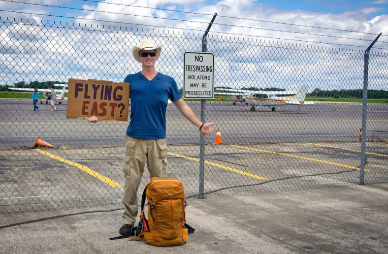 Homem pedindo carona no aeroporto